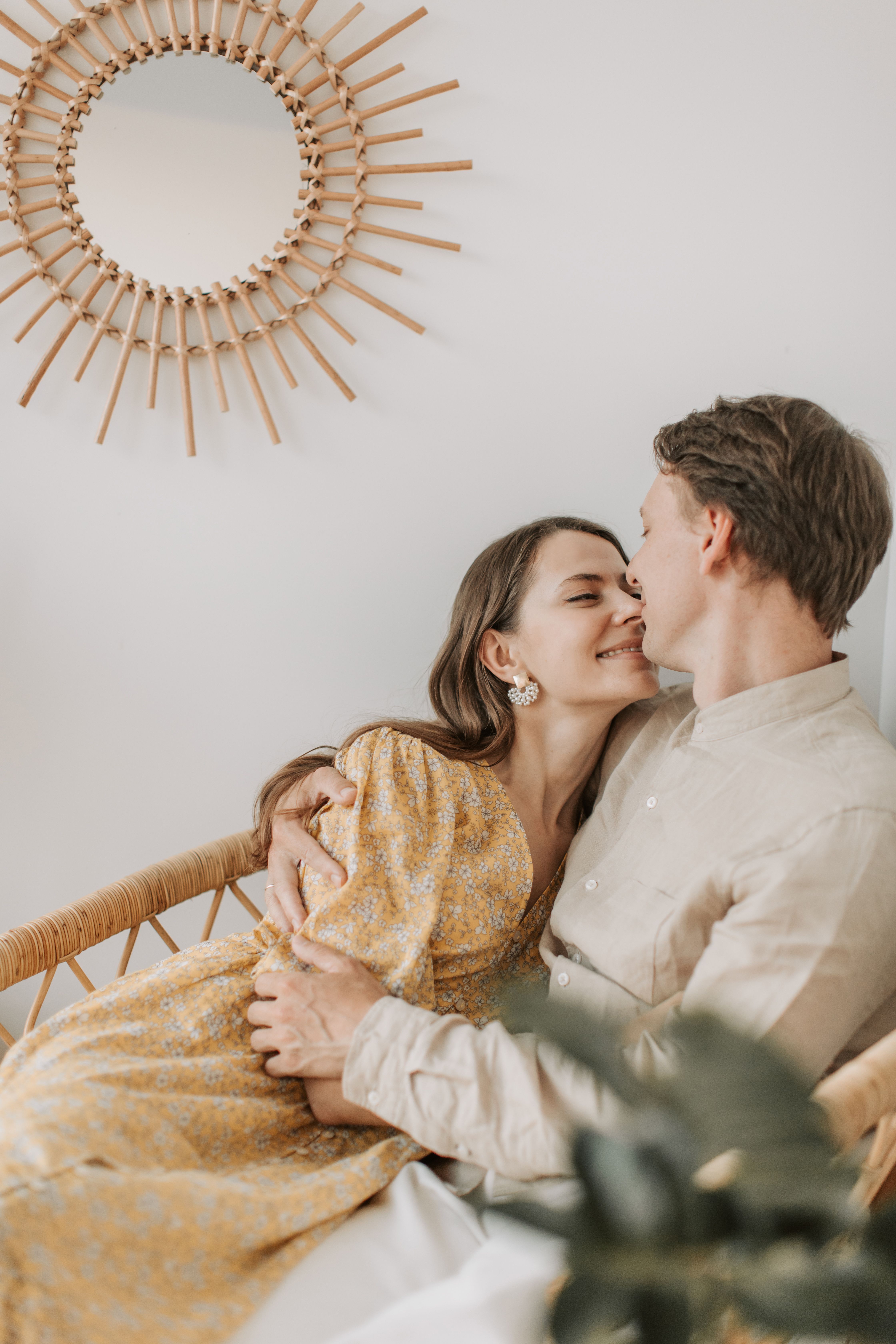 A couple shares an intimate moment while sitting together indoors, expressing love and affection.