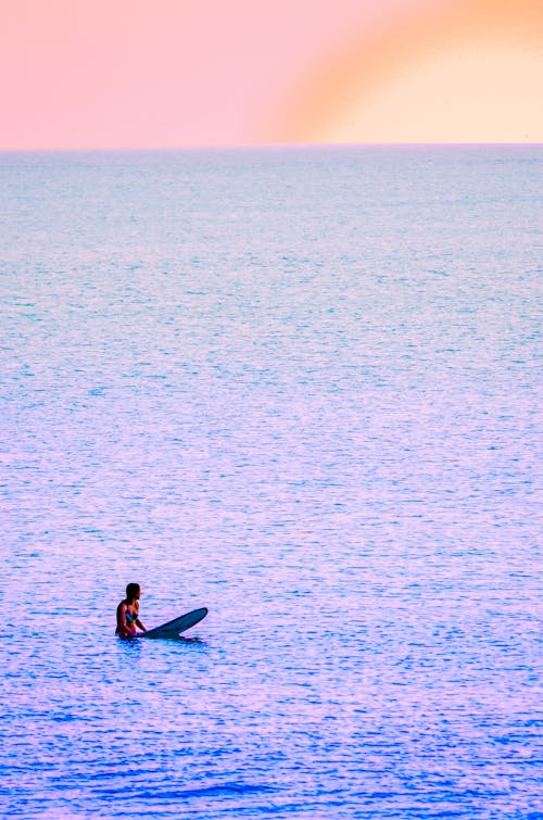 Free A Person on the Surfboard Floating on the Sea Stock Photo