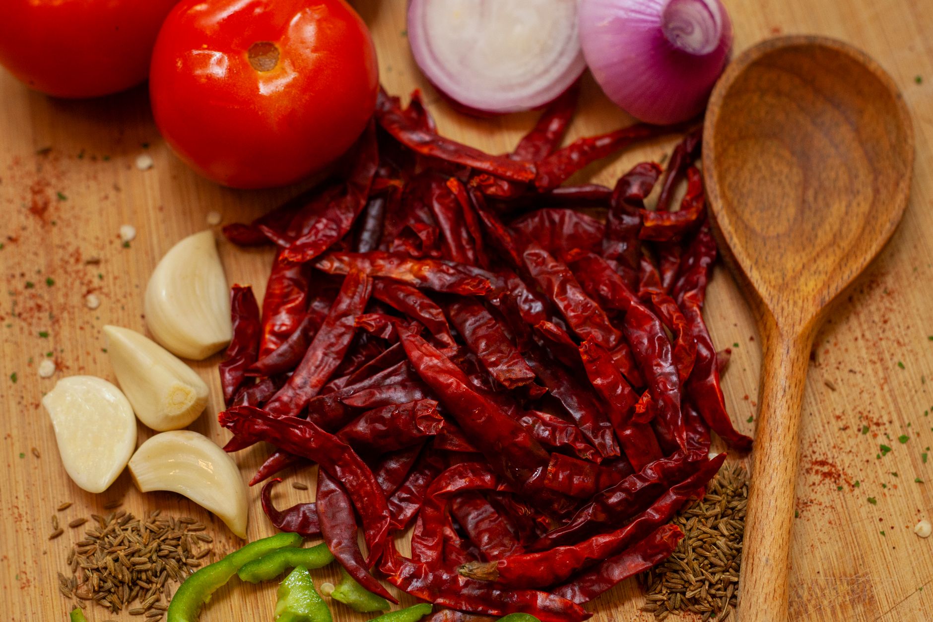 Colorful array of dried Indian chilies including Guntur, Byadgi, and Mathania varieties alongside traditional spices