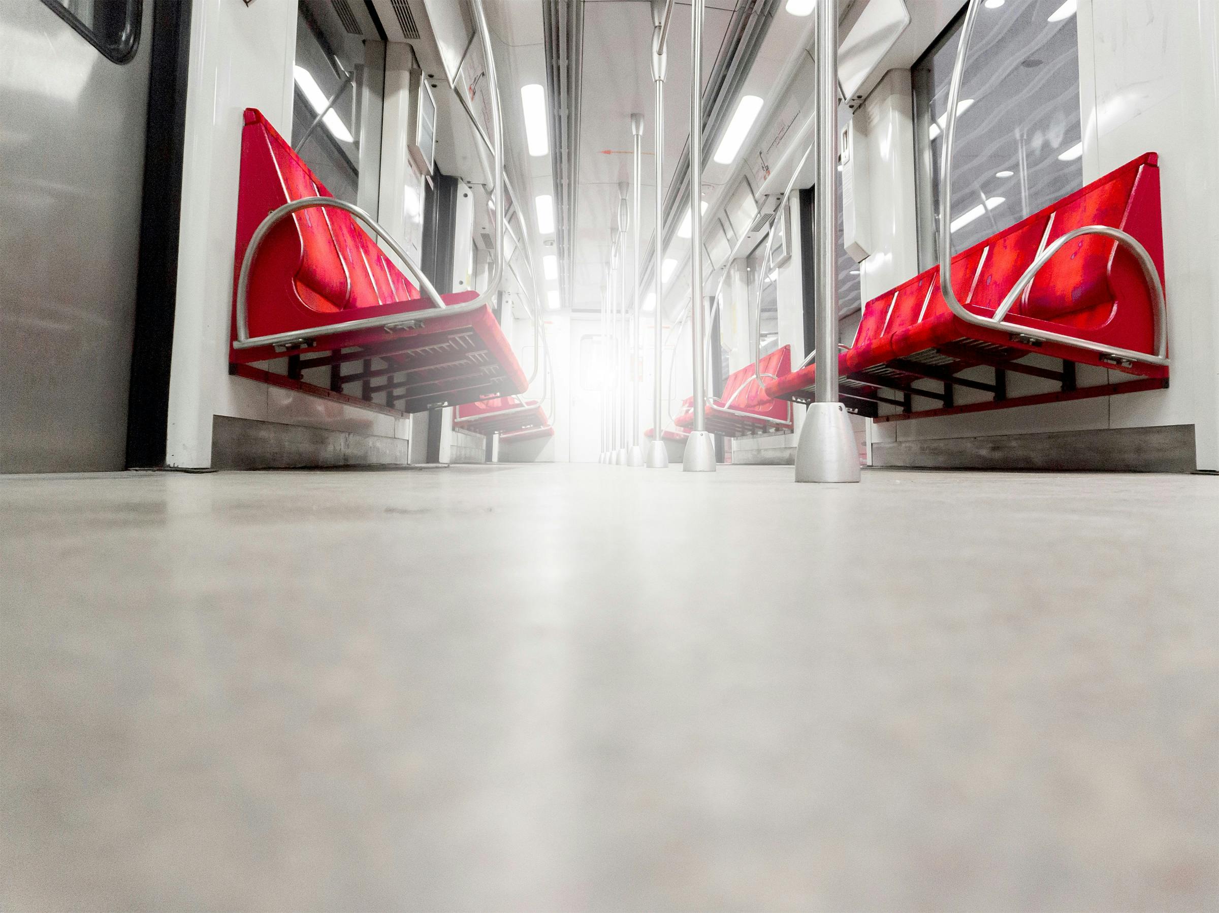 Free Low-angle view of a modern subway car interior with red seats and stainless steel fixtures, well-lit and empty. Stock Photo
