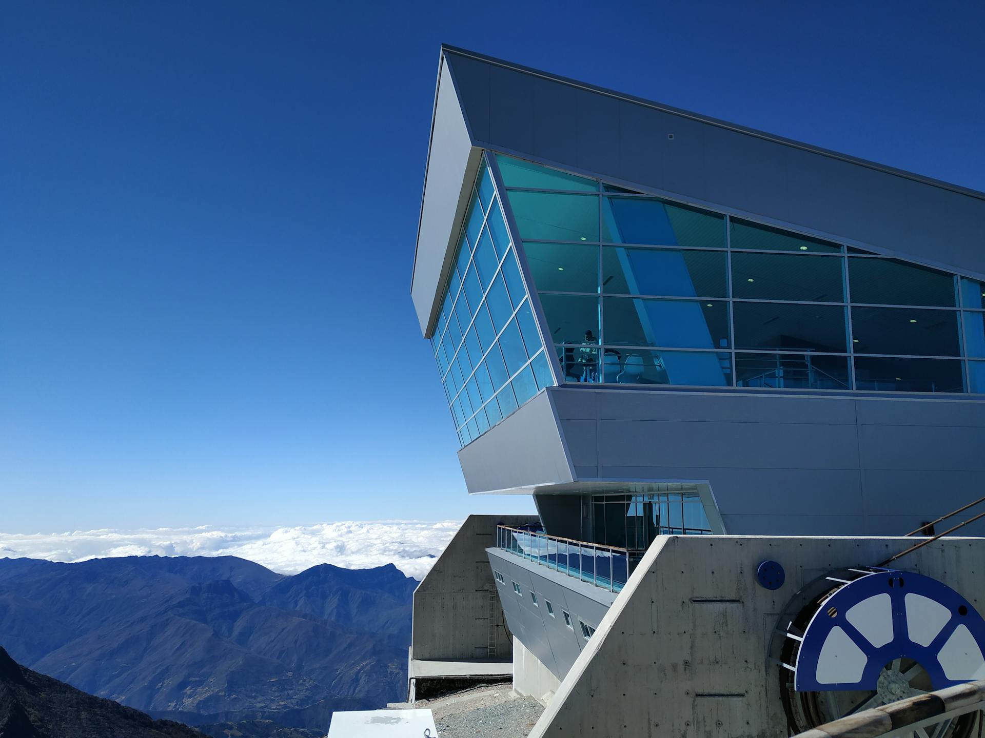 Contemporary building with glass windows atop the Venezuelan Andes under a clear blue sky.