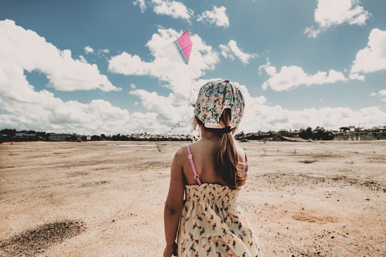 Anonymous Child Flying Kite On Beach On Sunny Day