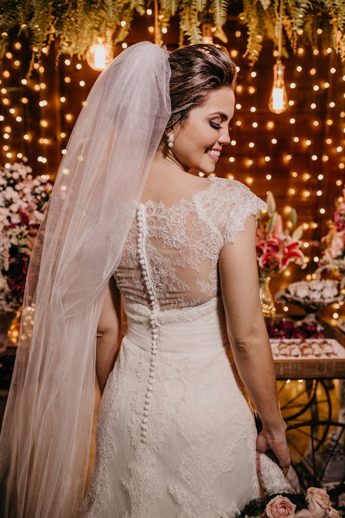 Cheerful young bride smiling while standing in richly decorated wedding room