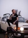 Man in Black Shirt Sitting on White Car