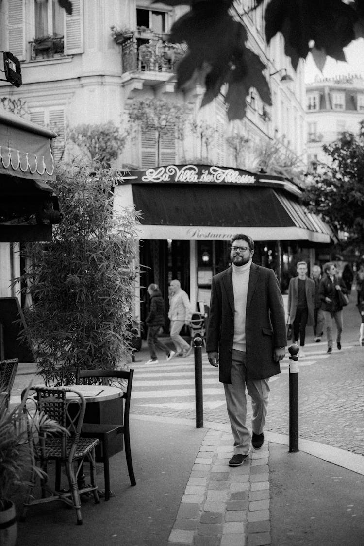 Man In Black Suit Standing Walking On The Sidewalk Near Restaurants