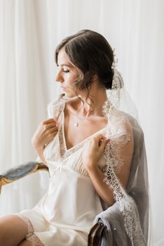 A beautiful bride in bridal lingerie with a lace veil, exuding bridal elegance and charm.