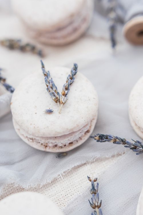 Free Delicate lavender macarons arranged artfully on fabric, adorned with lavender sprigs. Stock Photo