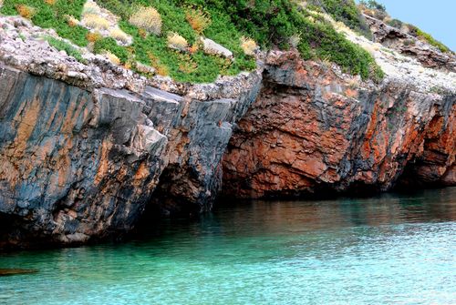 Free A stunning rocky coastline with clear turquoise waters and lush greenery. Stock Photo