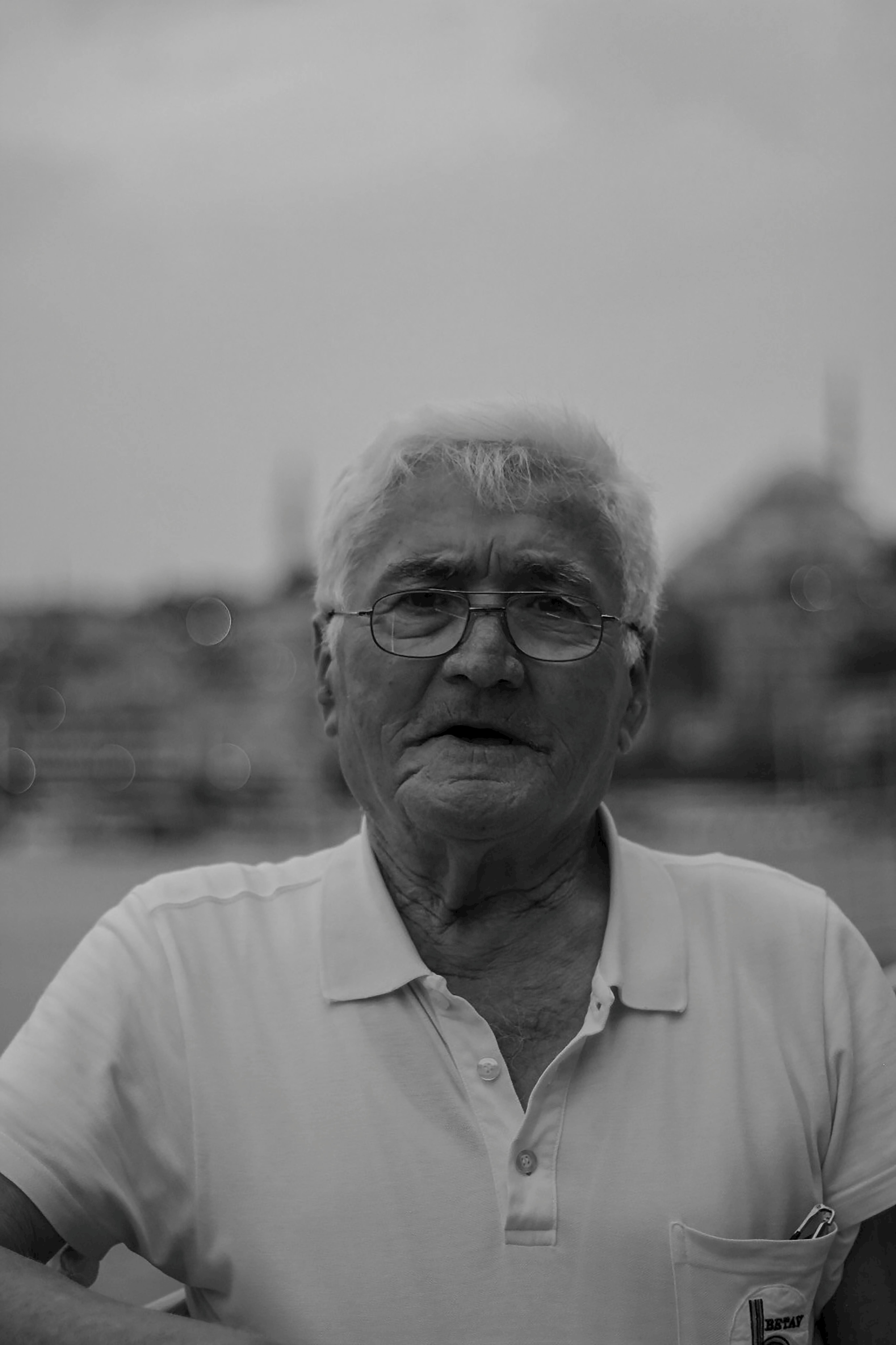 Artistic monochrome portrait of an elderly man with a serene expression, taken outdoors in Istanbul.