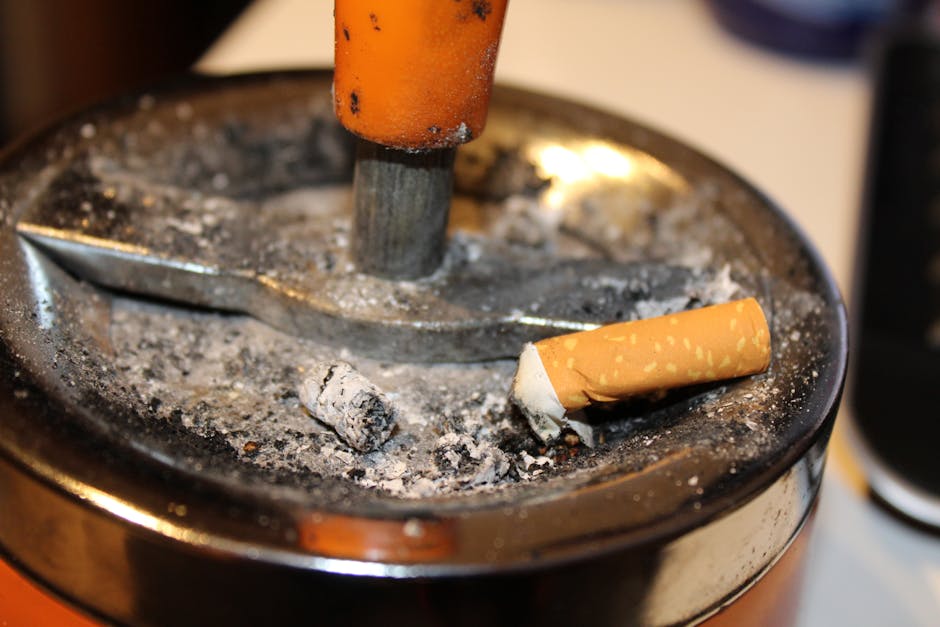 Gray Ashtray Filled With Cigarette Butt