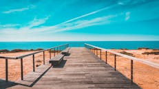 木板路通向田园诗般的大海，天空晴朗，海面平静