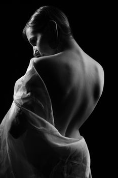Elegant monochrome portrait of a woman wrapped in fabric, showcasing grace and beauty.