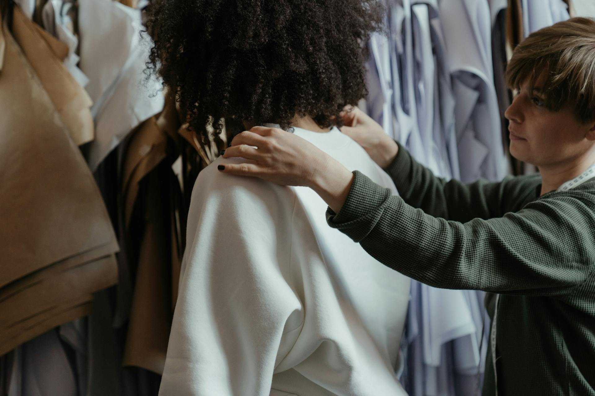 A fashion designer working on a garment in a clothing atelier.