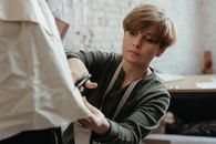 Professional tailor diligently cutting fabric in a contemporary sewing workshop.