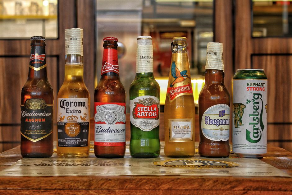 Collection of international beer bottles displayed on a bar counter.