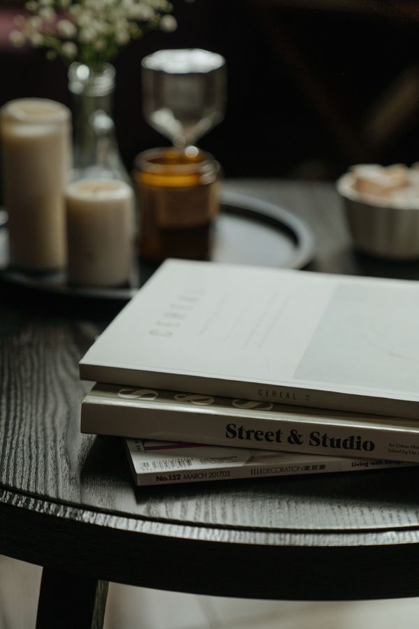 Books and candles arranged on a wooden table — photo by cottonbro studio on Pexels