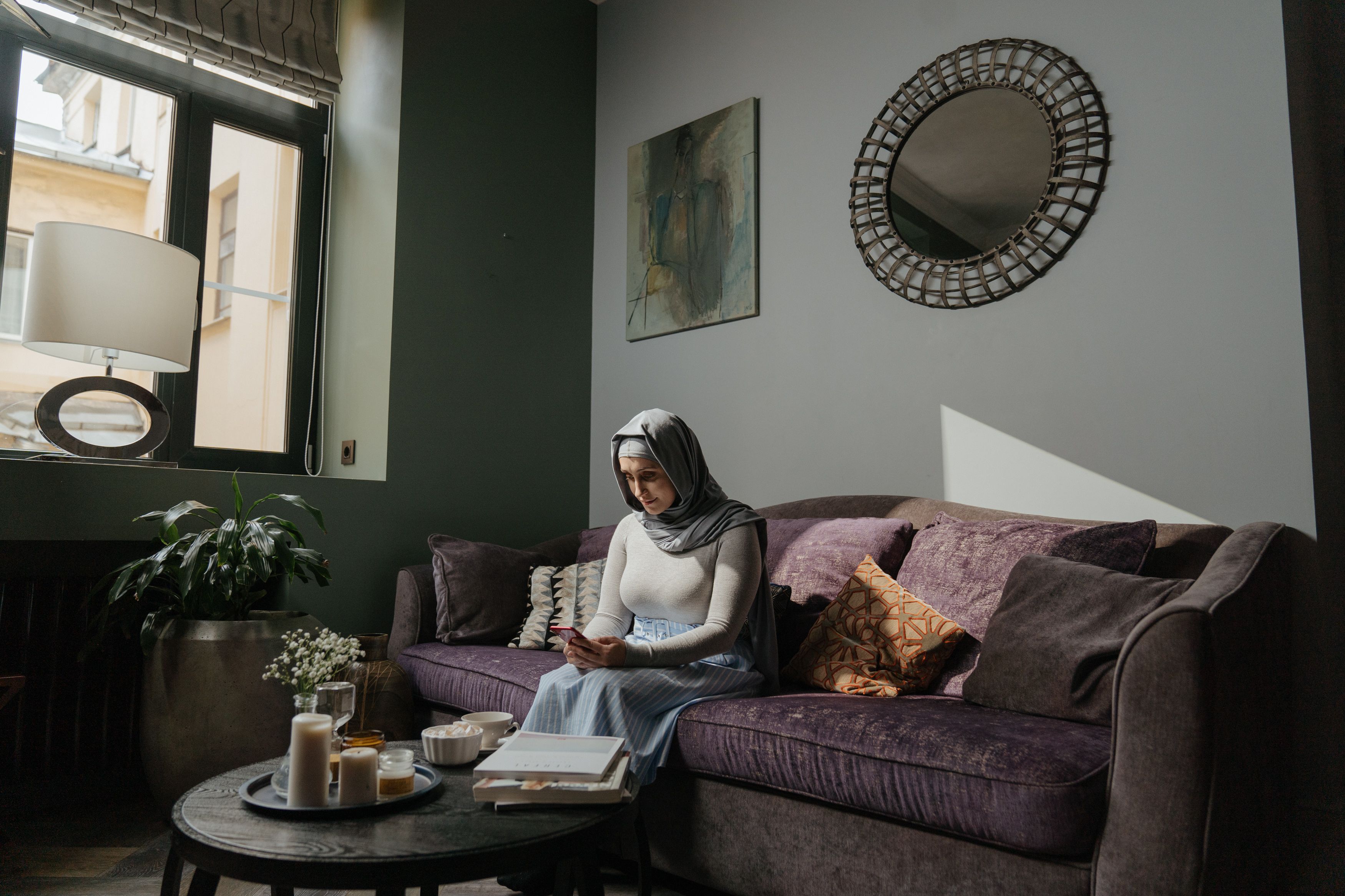 Woman in Gray Hijab Sitting on Couch · Free Stock Photo