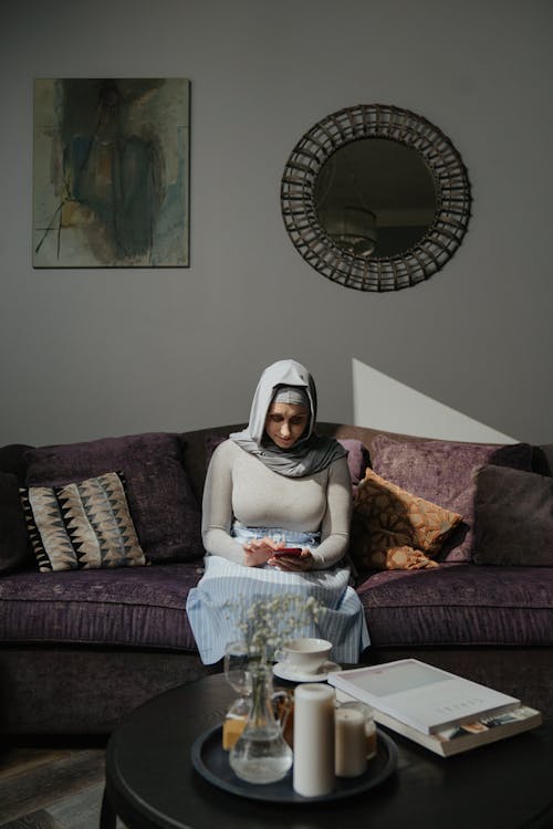 Free Woman in White Hijab Sitting on Brown Sofa Stock Photo