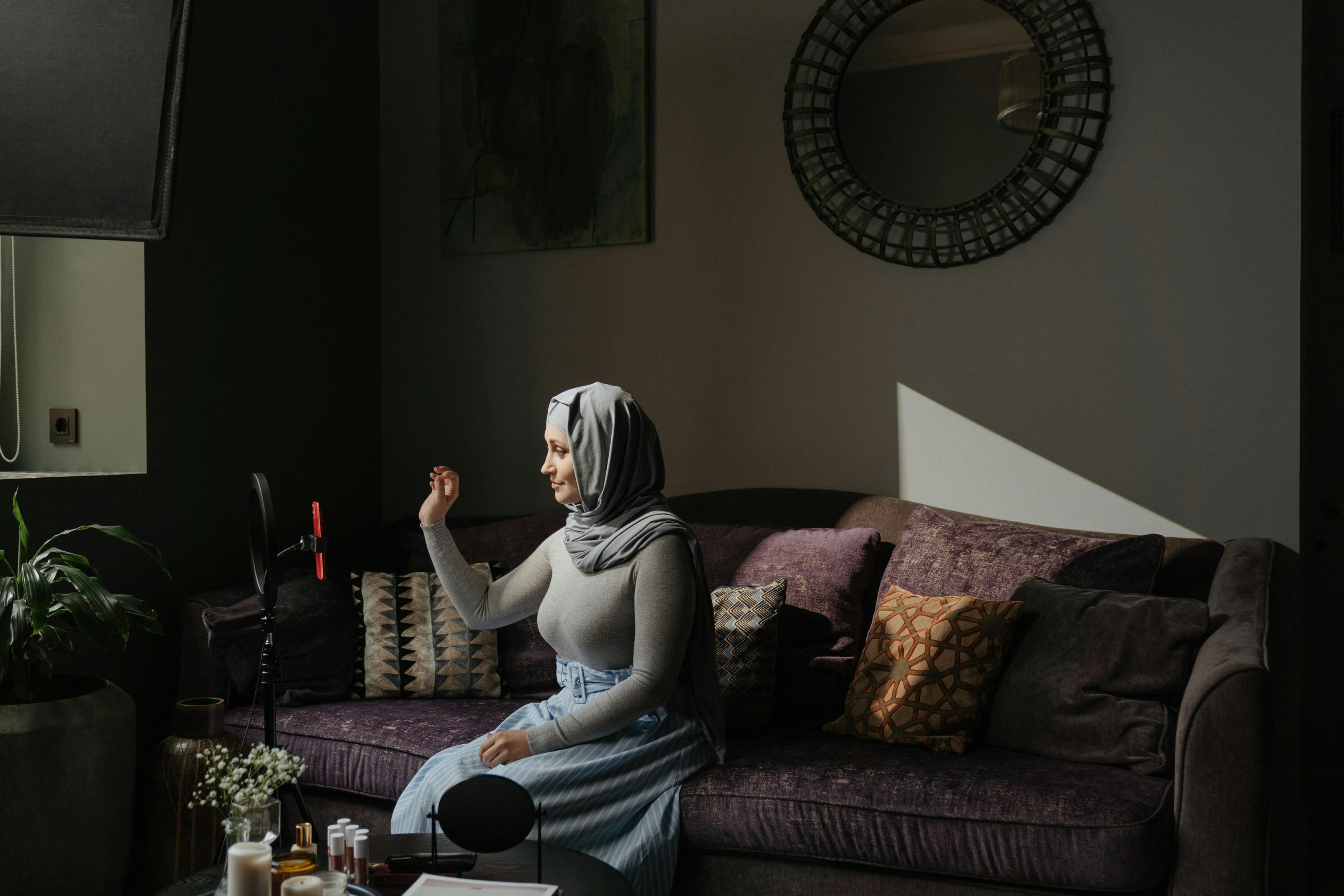 Woman in Gray Hijab Sitting on Brown Couch · Free Stock Photo