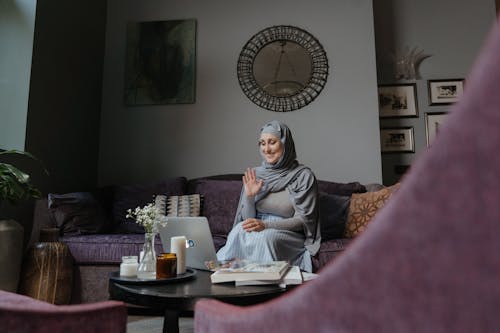Free Woman in Gray Hijab Sitting on Couch Stock Photo