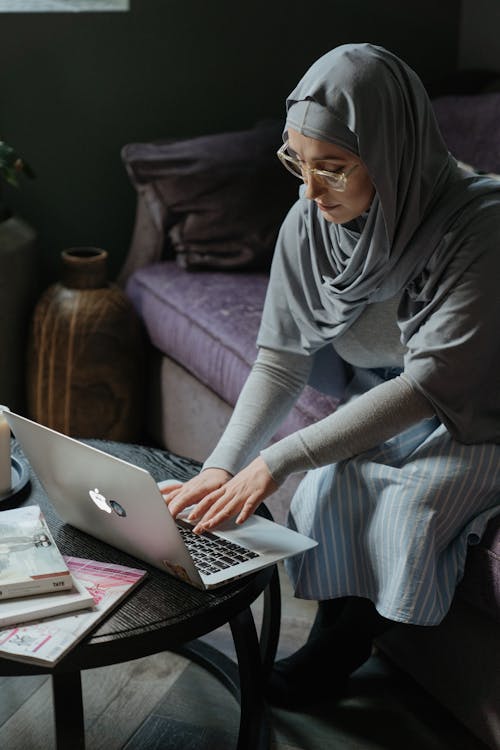 Woman in Gray Hijab Using Macbook Air