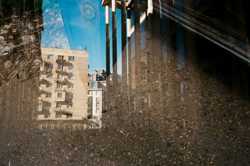 Free Through glass of old multi storey construction reflecting from ground covered with water in daylight Stock Photo