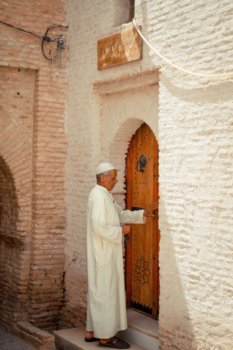 Catholic Priest In Front Of Entrance To Building