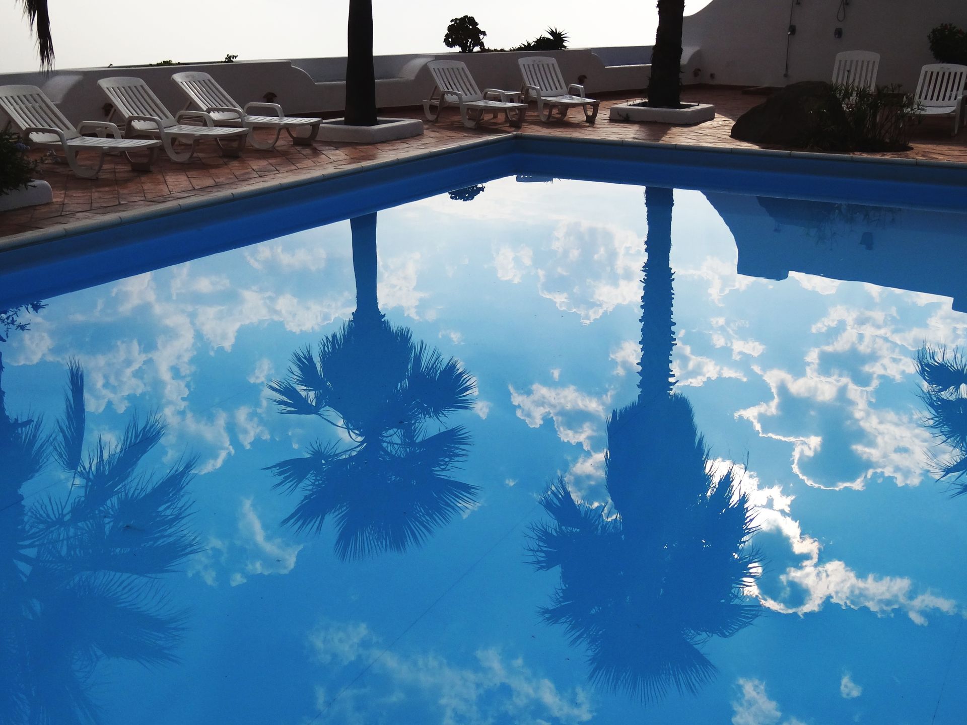 White Loungers Beside Swimming Pool