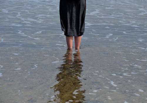Free Woman in Black Skirt Standing on Water Stock Photo