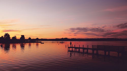 Free Silhouette Photography of Man Standing on Dock Stock Photo