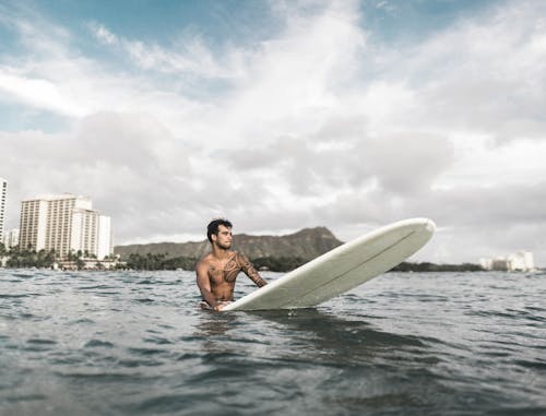 Photo Of Man Riding A Surfboard