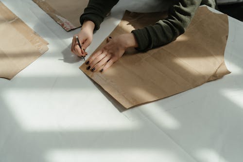 Person in Black and Gray Long Sleeve Shirt Holding Brown Wooden Board