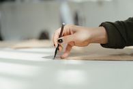 Person Writing on White Paper