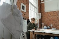 在一间阳光明媚、砖墙质朴的工作室里，一位敬业的女裁缝正专注于她的手艺