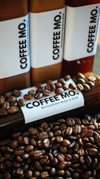 Vertical shot of Coffee Mo bottles and roasted beans showcasing aromatic coffee delight.