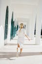 一位金发女子优雅而充满动感地穿过阳光明媚的走廊