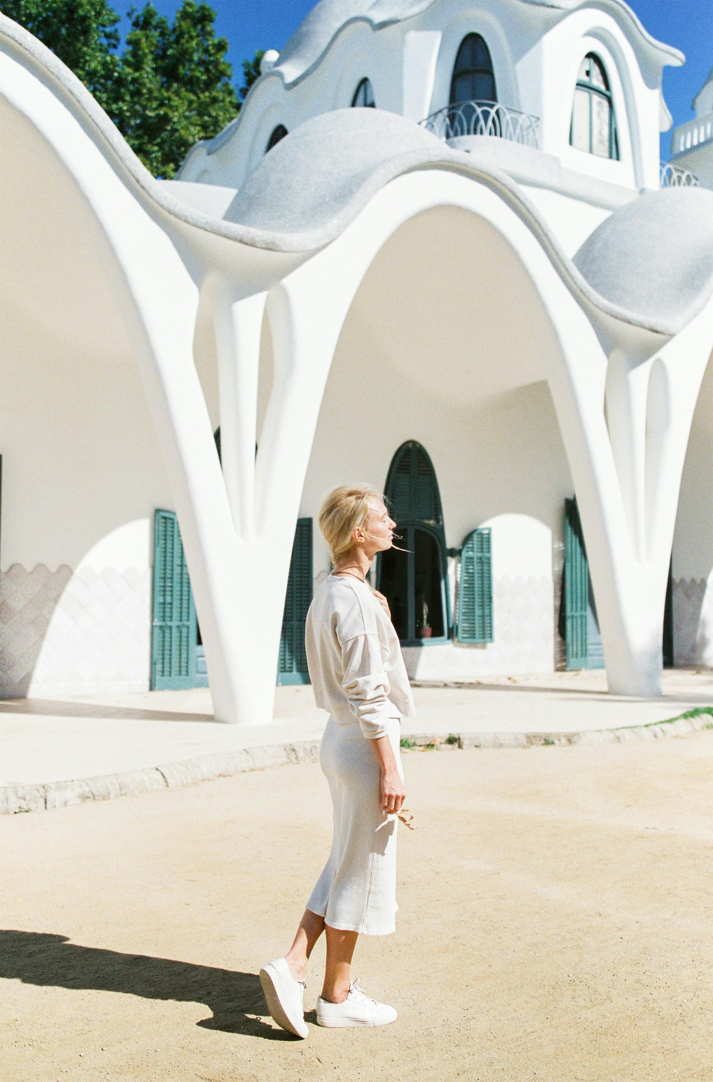 Woman in White Long Sleeve Shirt and White Pants Walking on White