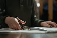 裁缝用剪刀剪布料的特写手部镜头，突出工艺与技巧