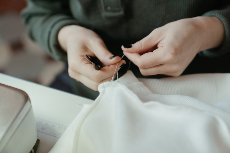 Hands sewing fabric at a workshop