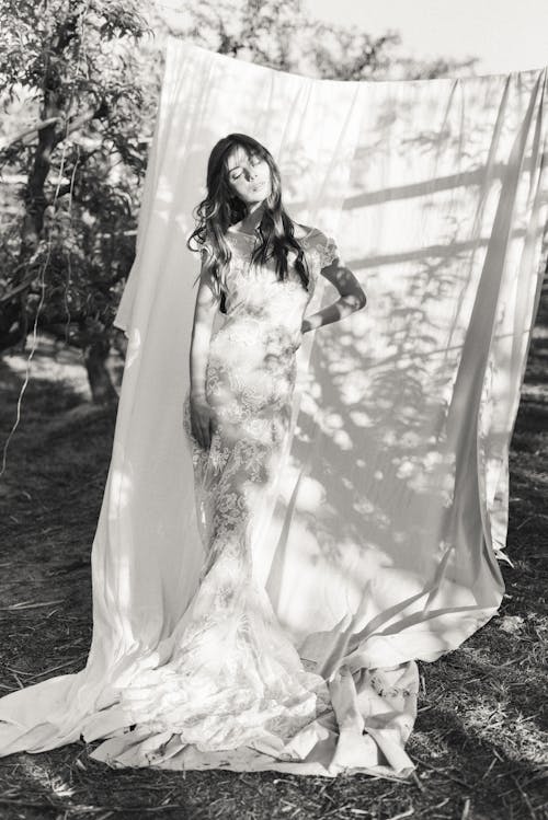 숲에 서있는 하얀 웨딩 드레스에 여자