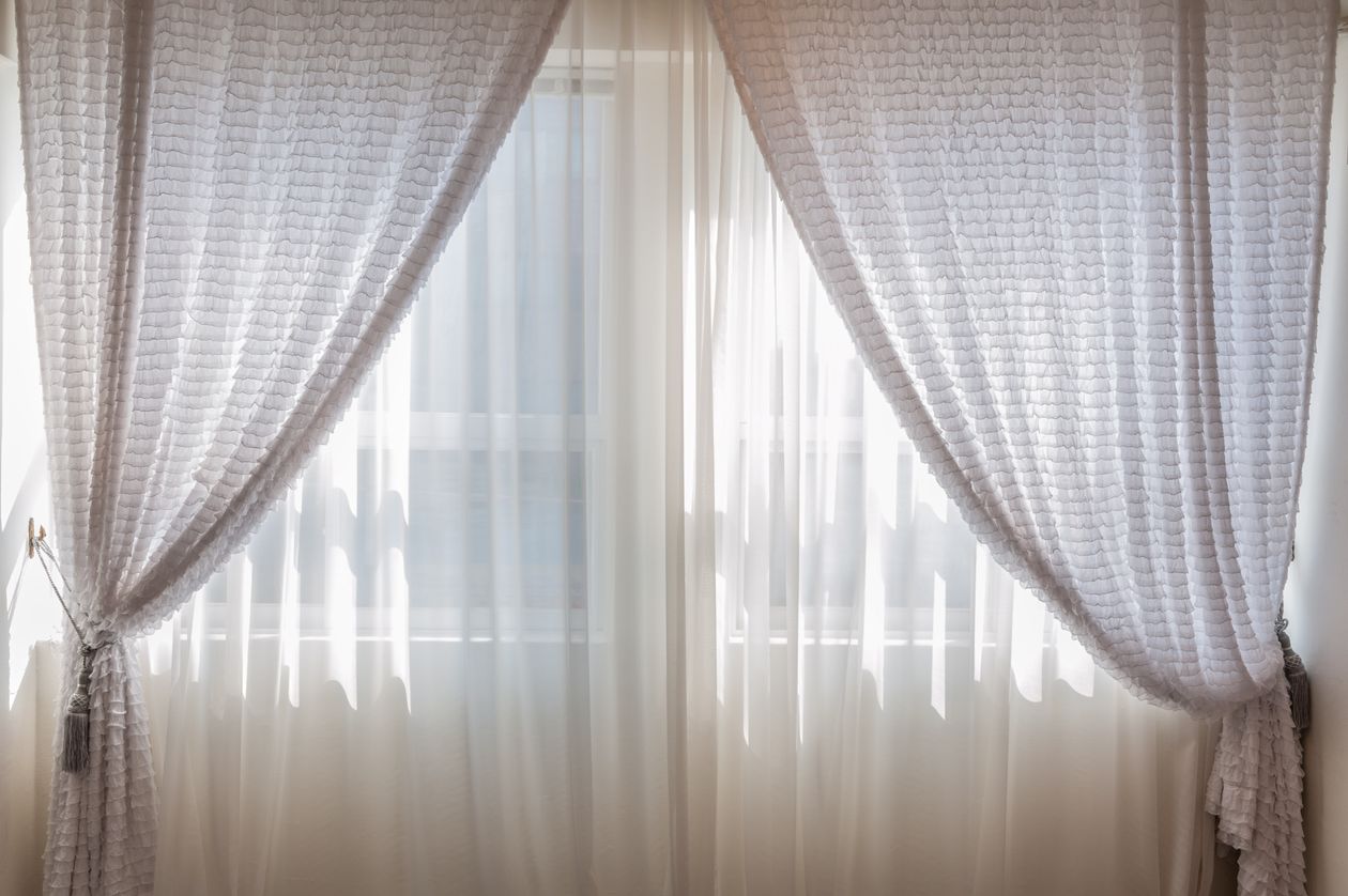 White lace curtains just touching the floor