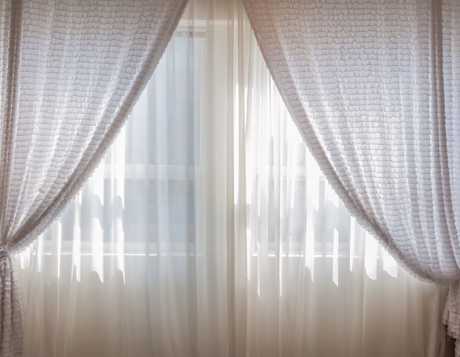 Sunlight through sheer curtains in a quiet room