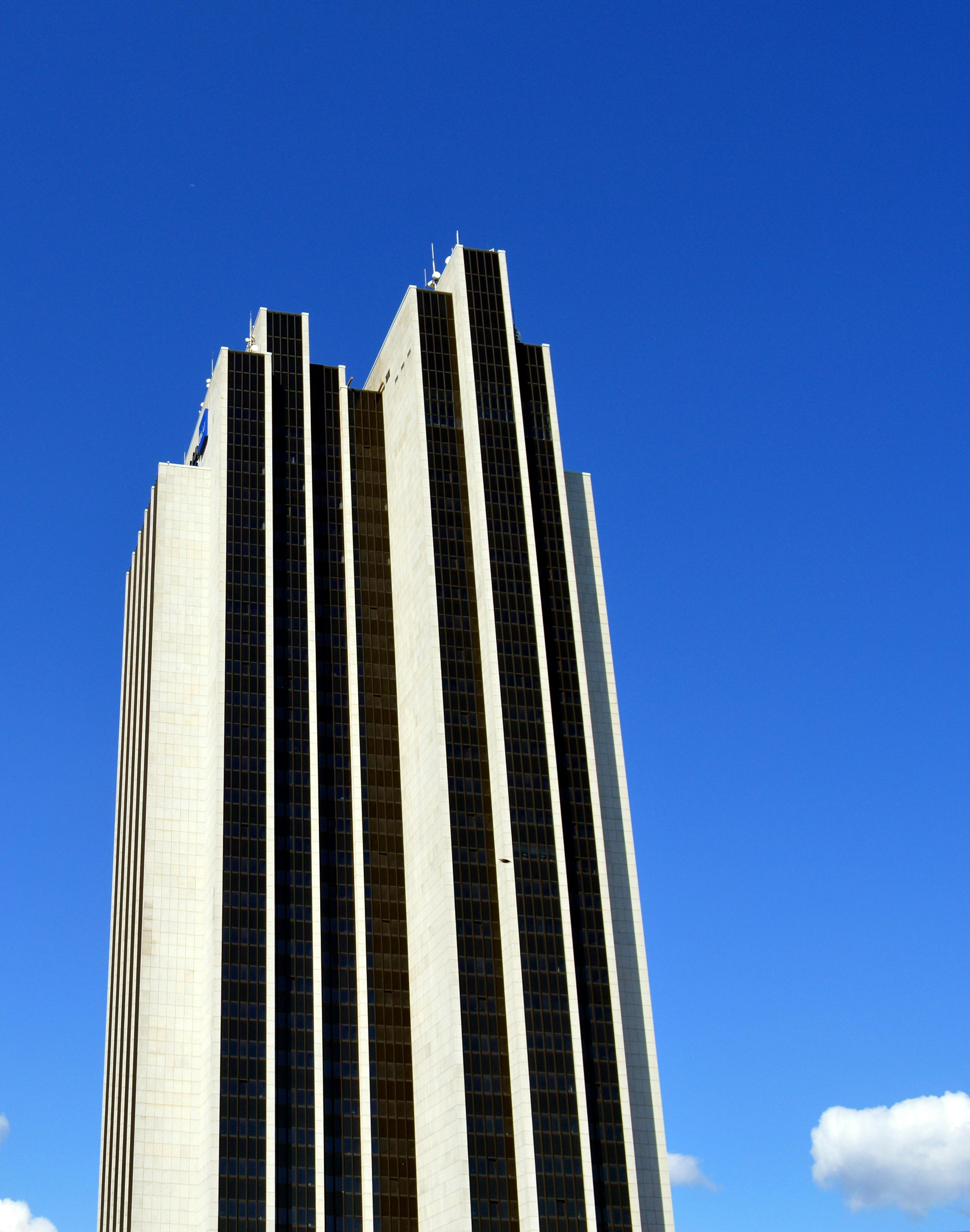 当代摩天大楼与玻璃立面在蓝天下，展示着城市建筑