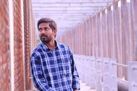Ethnic man standing on passage in construction