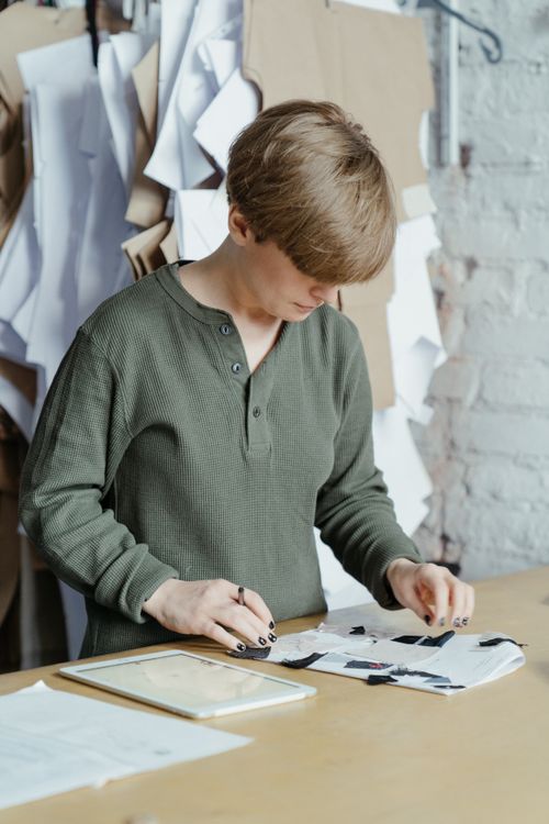 Free A designer intensely working on patterns with an iPad in a sewing workshop. Stock Photo