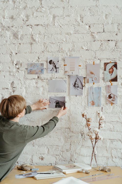 Woman in Gray Long Sleeve Shirt Writing on White Board