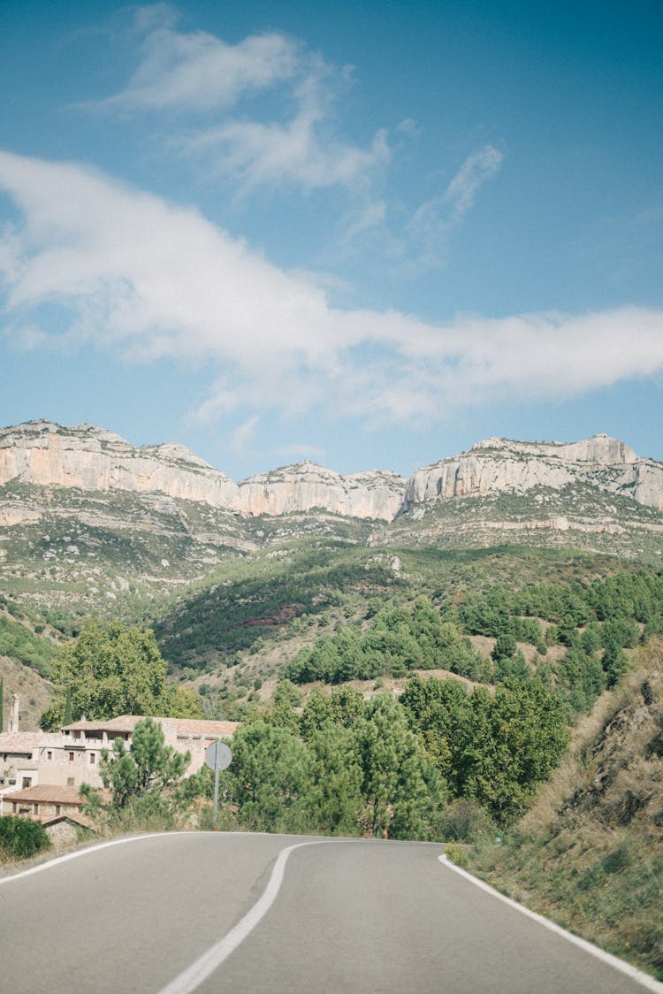 A Curved Road With View Of A Rock Mountain