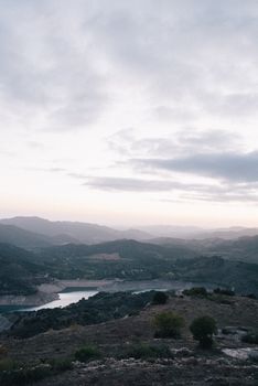 黄昏时分，多云天空下，山景宁静，湖泊也一片宁静