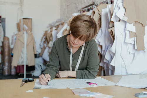 Free Woman in Gray Cardigan Writing on White Paper Stock Photo