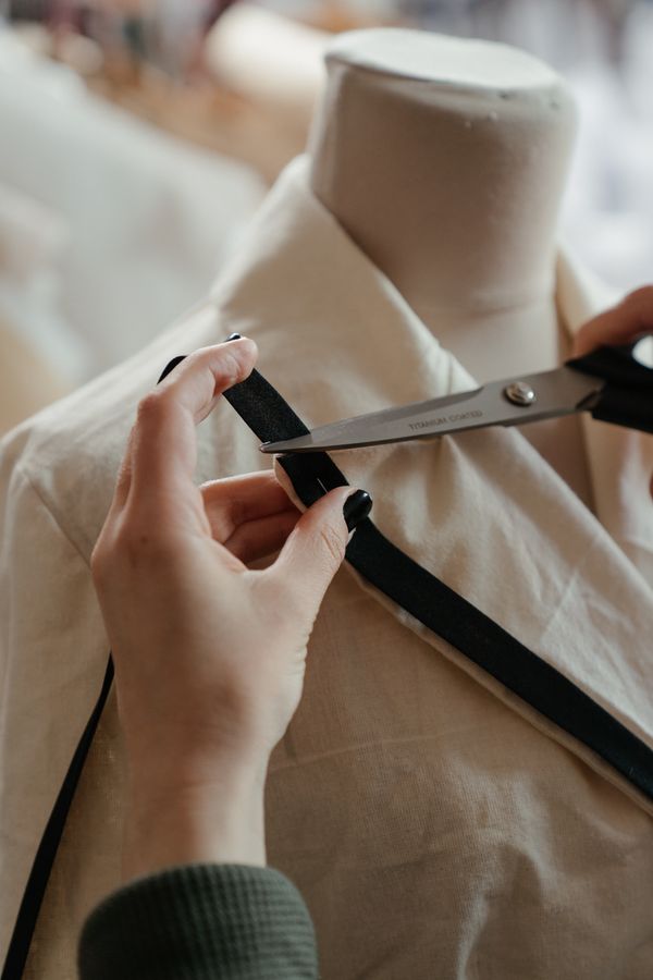 Fashion pattern-making workspace with collar, neckline, facing, and button-extension paper patterns